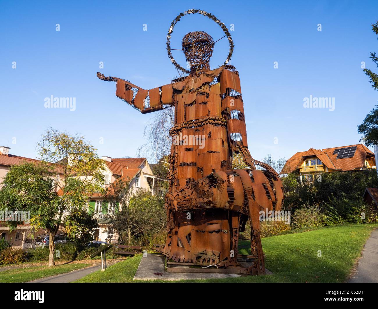 Statue von Franz von Assisi aus rostigem altem Eisen, die die Zähmung des Wolfs von Gubbio durch Franz von Assisi, Tieschen, Steiermark, Österreich darstellt Stockfoto