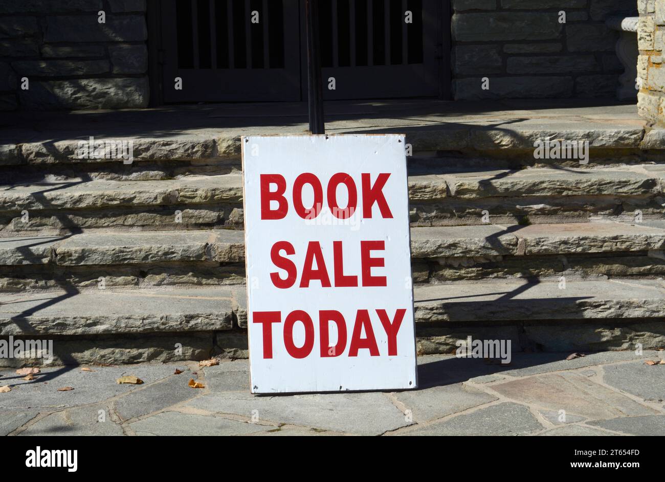 Ein Schild vor einer öffentlichen Bibliothek wirbt für einen Buchverkauf in Blowing Rock, North Carolina. Stockfoto