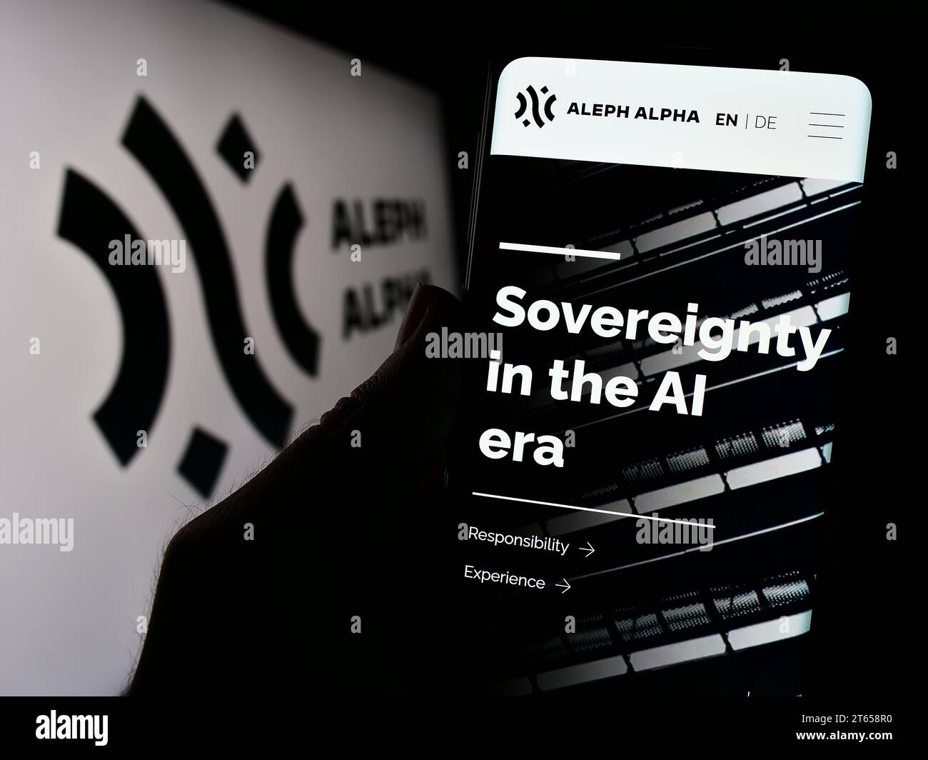 Handybesitzer mit Webseite des deutschen Künstlichen Intelligenz-Unternehmens Aleph Alpha GmbH mit Logo. Konzentrieren Sie sich auf die Mitte des Telefondisplays. Stockfoto