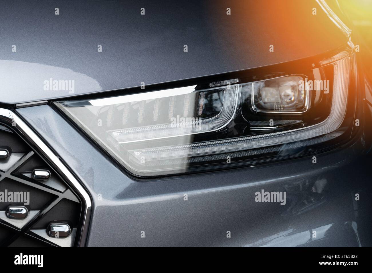 Moderner Auto-LED-Scheinwerfer aus nächster Nähe auf grauem Metallic-Oberteil Stockfoto