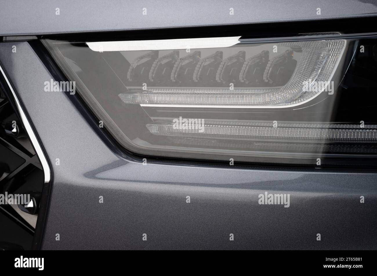 Glänzender, reflektierender LED-Scheinwerfer in grauer Farbe aus der Nähe des Fahrzeugs Stockfoto