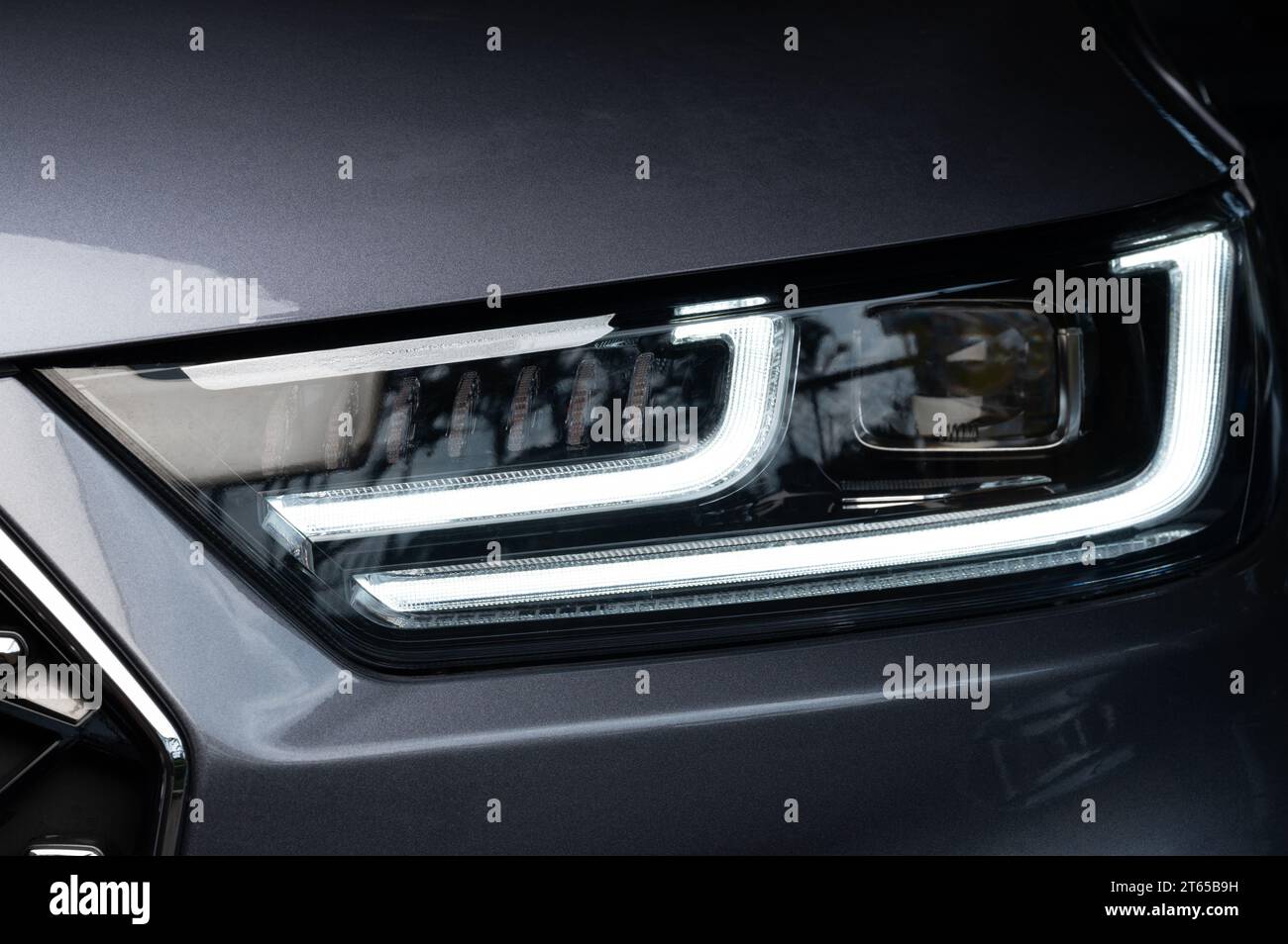 Reinigen Sie teure LED-Scheinwerfer auf grauem Auto aus nächster Nähe Stockfoto