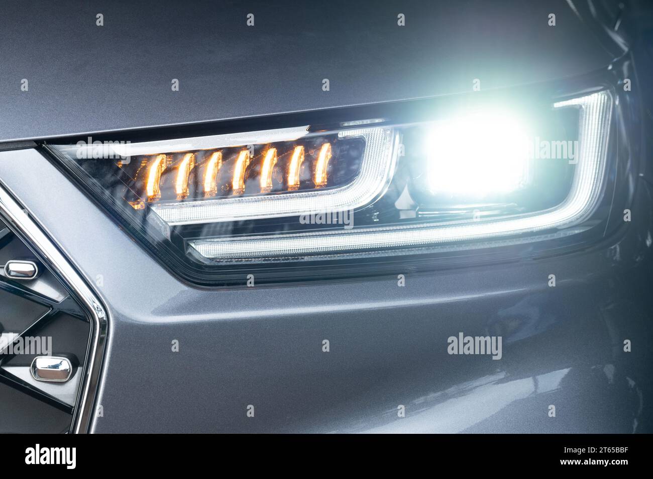 Neue, glänzende LED-Frontleuchte in grauer Farbe aus der Nähe des Fahrzeugs Stockfoto