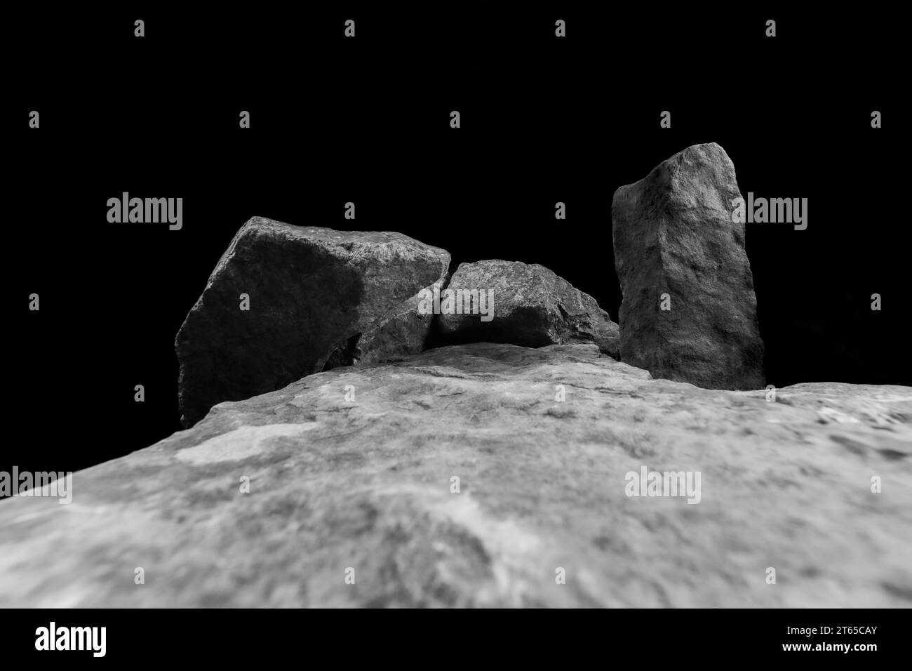 Ein Weitwinkel eines Felsens für eine Produktanzeige, der einen unscharfen Vordergrund zeigt, der zu einem mittleren Stein mit einem hellen Schatten auf der natürlichen Struktur führt. Stockfoto