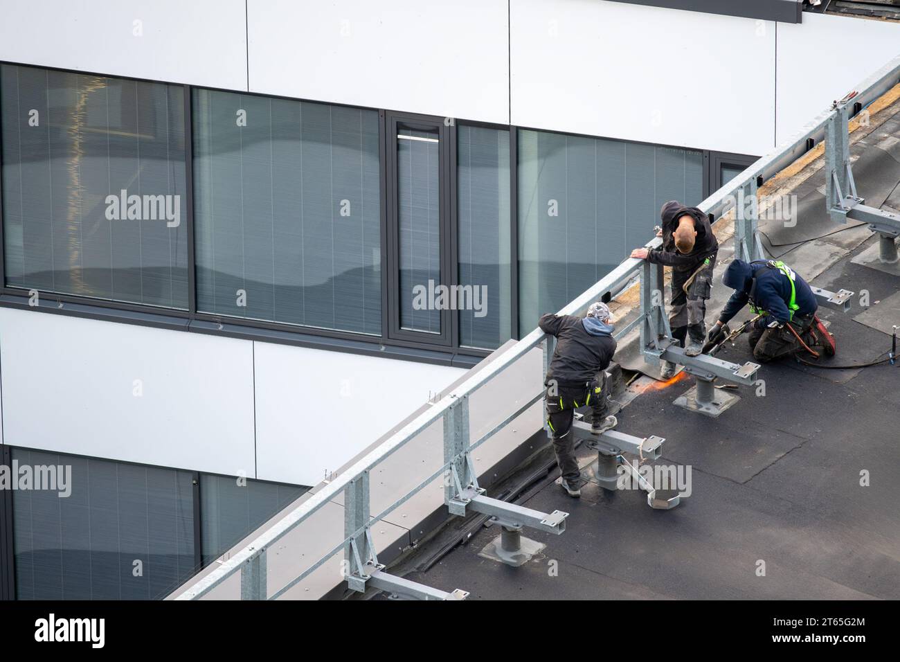 Vogelperspektive auf eine Dachbaustelle. Professionelle Bitumen-Abdichtung auf einem flachen Gebäude. Stockfoto