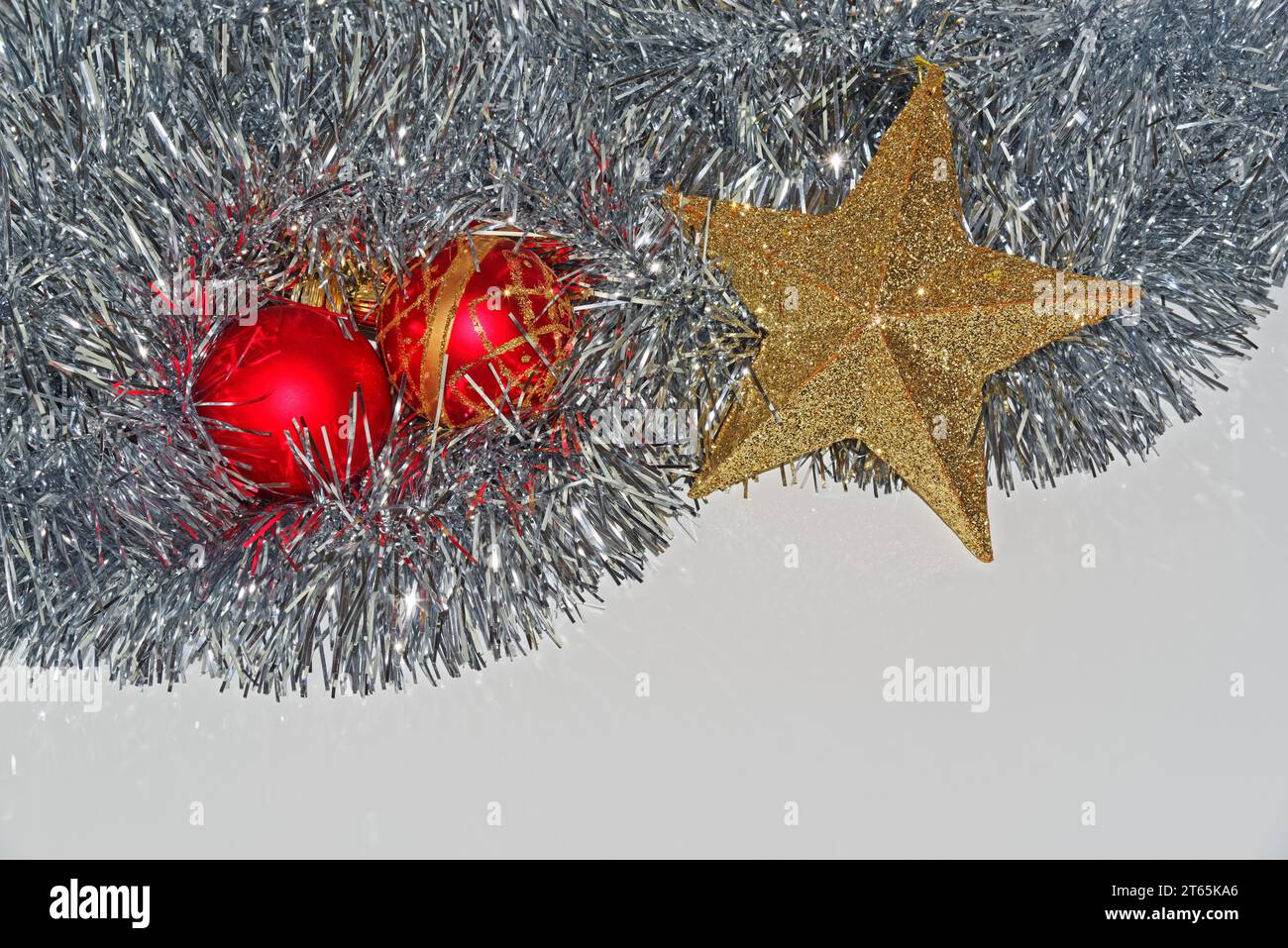 Weihnachtsdekoration auf weißem Hintergrund, zwei rote Kugeln und goldfarbener Stern Stockfoto