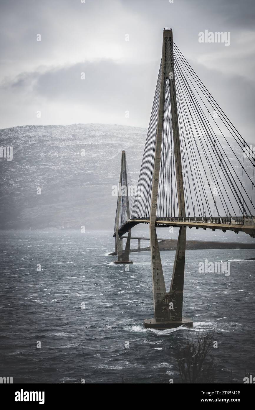 Malerisches vertikales Foto auf der Sandnessjoen Brücke sehr windiger Tag, Spätherbst, niedrige Wolken über dem Vefsnfjord. Ansicht von der linken Seite. Auto reisen mit NOR Stockfoto