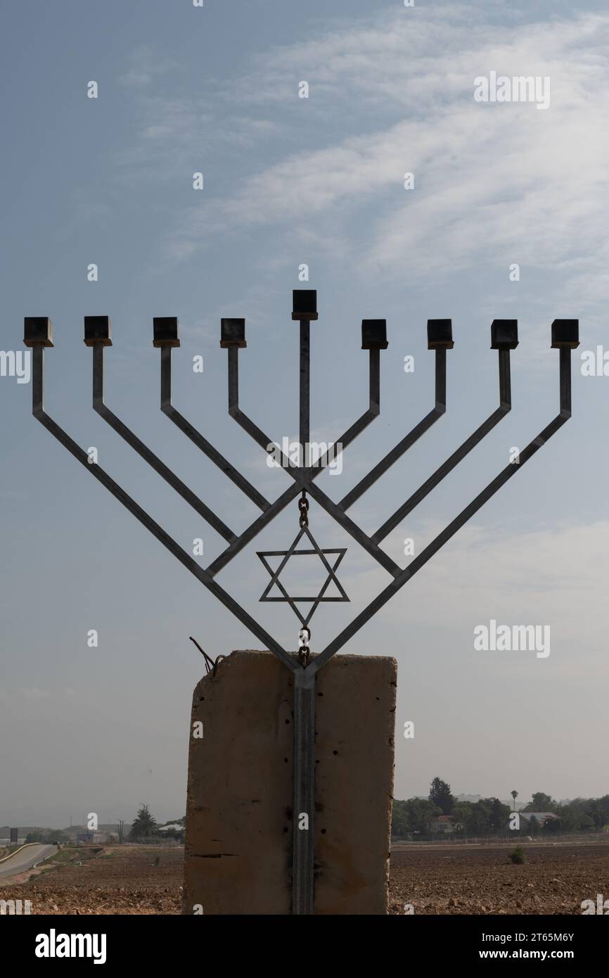 Eine große, achtverzweigte Hanukka-Menora aus Metall, die auf einem Betonfundament errichtet und entlang einer Autobahn im Jordantal in Israel aufgestellt wurde. Stockfoto