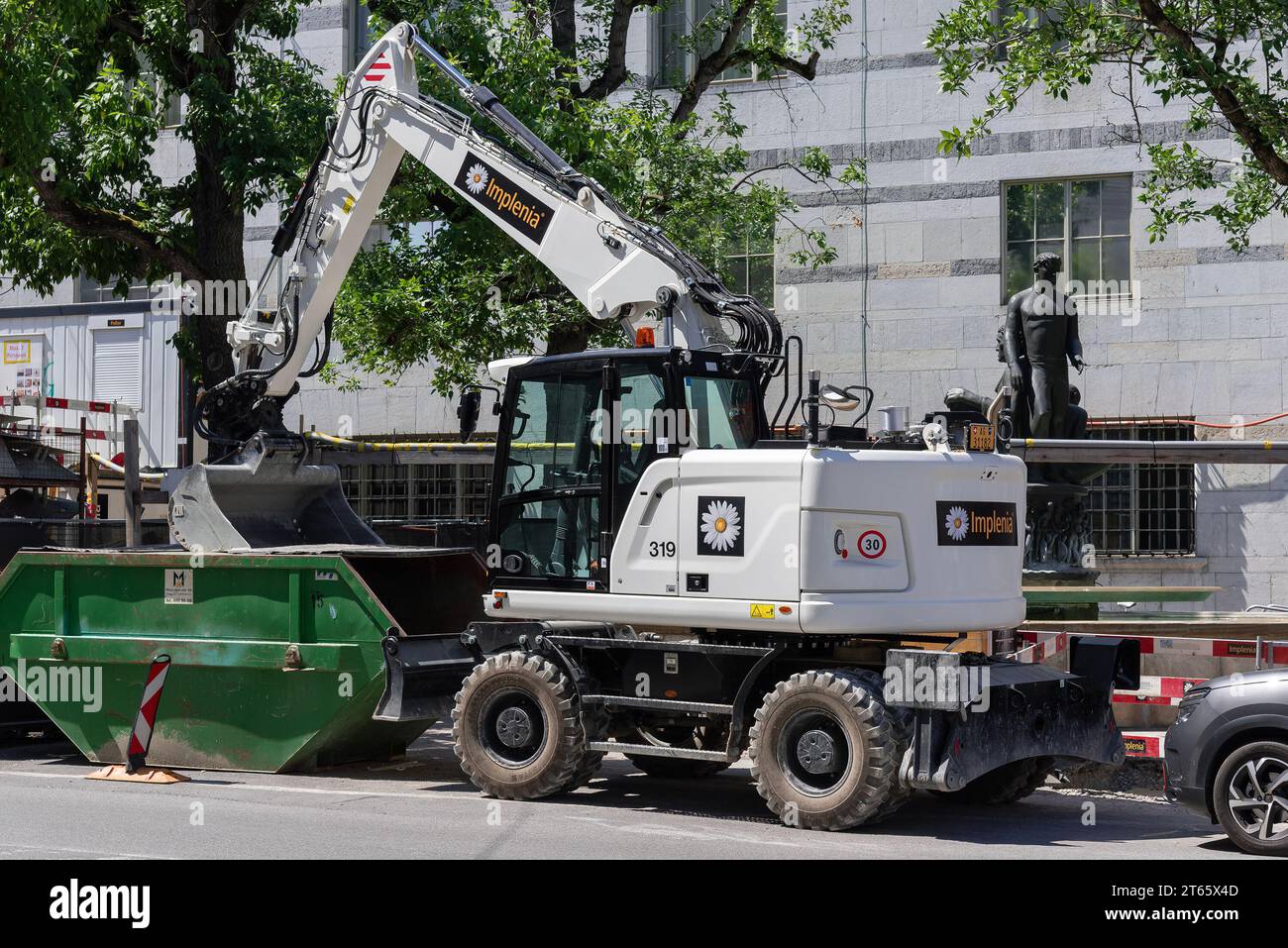 Basel, Schweiz – Weißradbagger CAT M317F auf einer Straße in Basel. Stockfoto