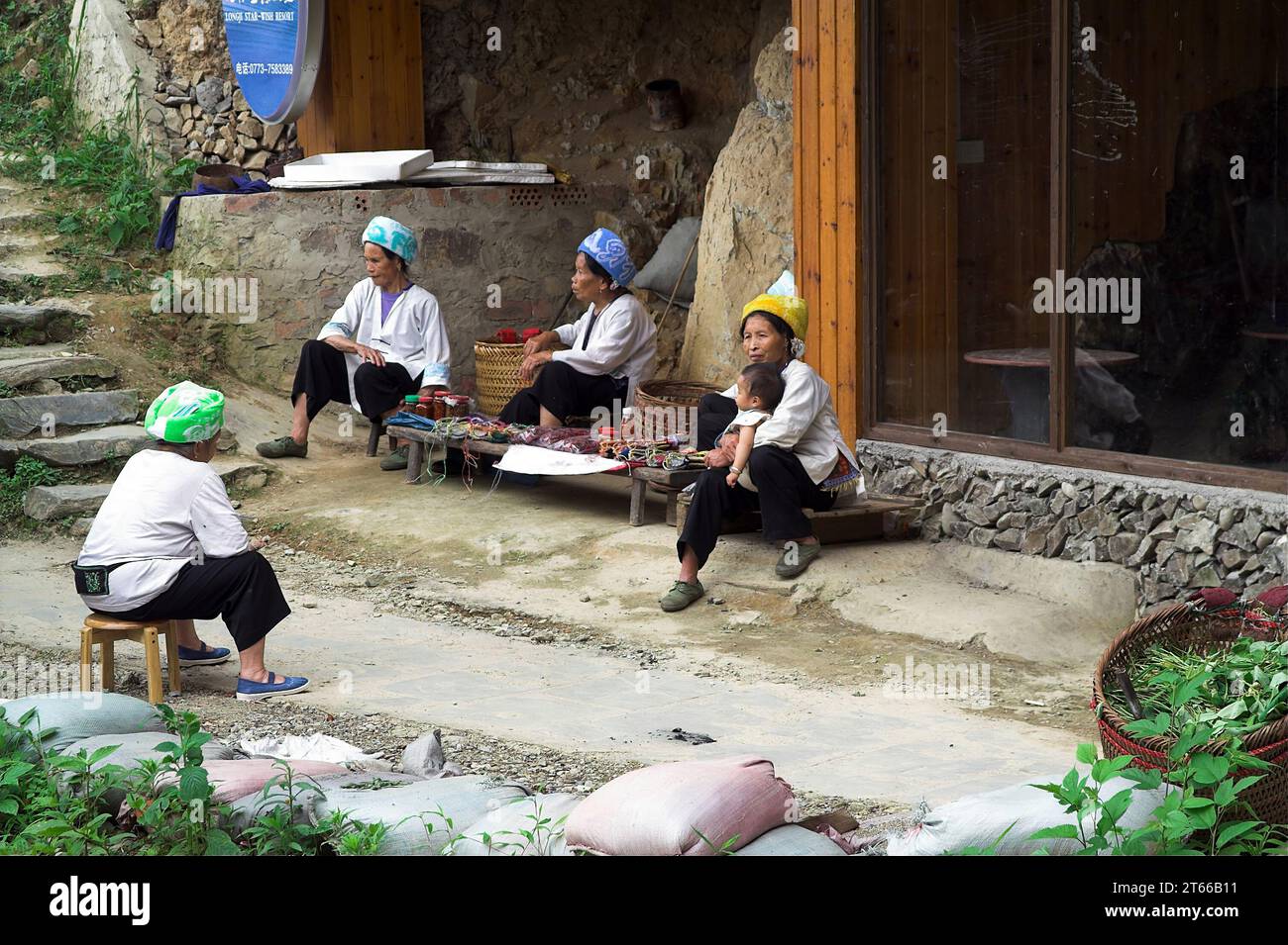 龙胜镇 (龙胜县) 中國 Longsheng, Longji Ping'an Zhuang, China; Chinesische Frauen sitzen an einem kleinen Stand; Chinesische Frauen sitzen an einem kleinen Stand Stockfoto