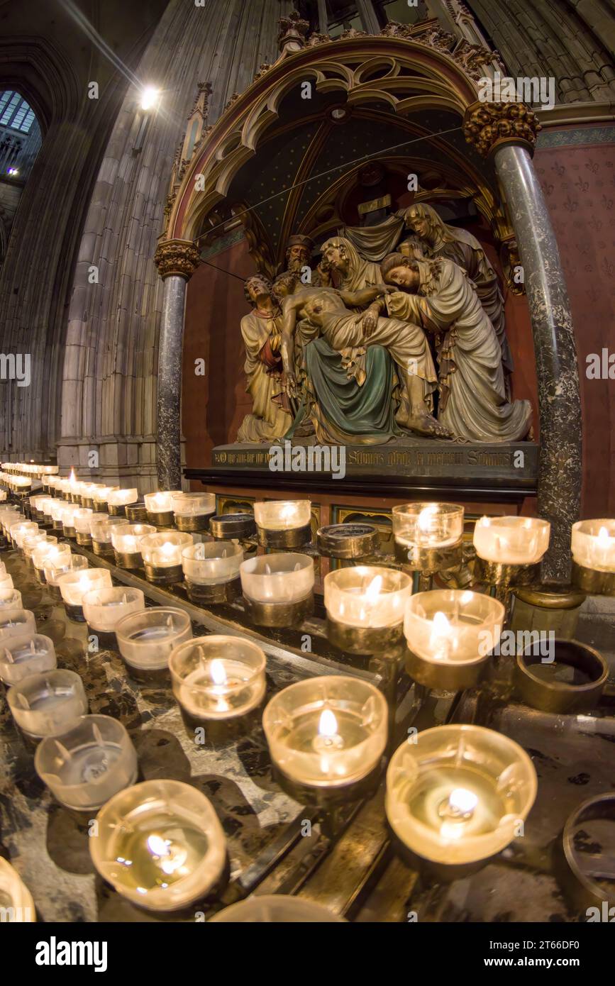Gebetskerzen und die 13. Kreuzstation im Kölner Dom. Stockfoto