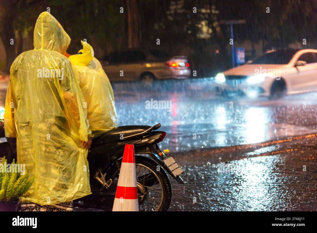 Chiang Mai, Thailand-16. März 2023: Autos rasen gefährlich entlang des Umkreises der Altstadt von Chiangmai durch Regenpfützen in einem sintflutartigen Regenguss Stockfoto