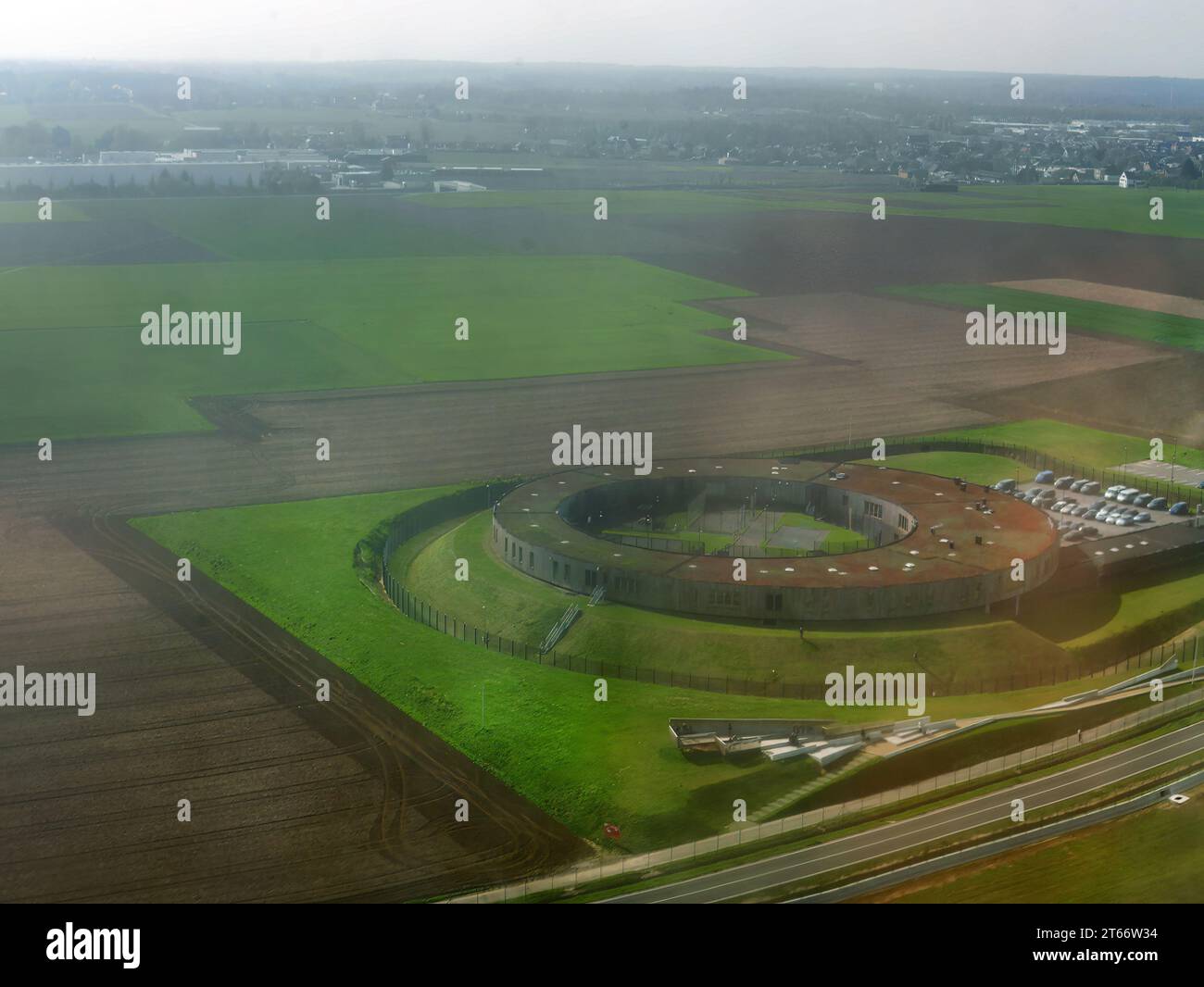 Luftaufnahme vom Flugzeug aus mit großem kreisförmigem Gebäude, Architekturdesign, auf Grünfläche, Blick von oben Stockfoto