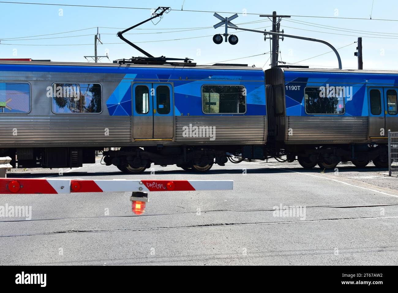 Melbourne, Victoria, Australien, 01012023: Ein U-Bahn-Zug überquert einen Bahnübergang an der Coburg North Station Stockfoto