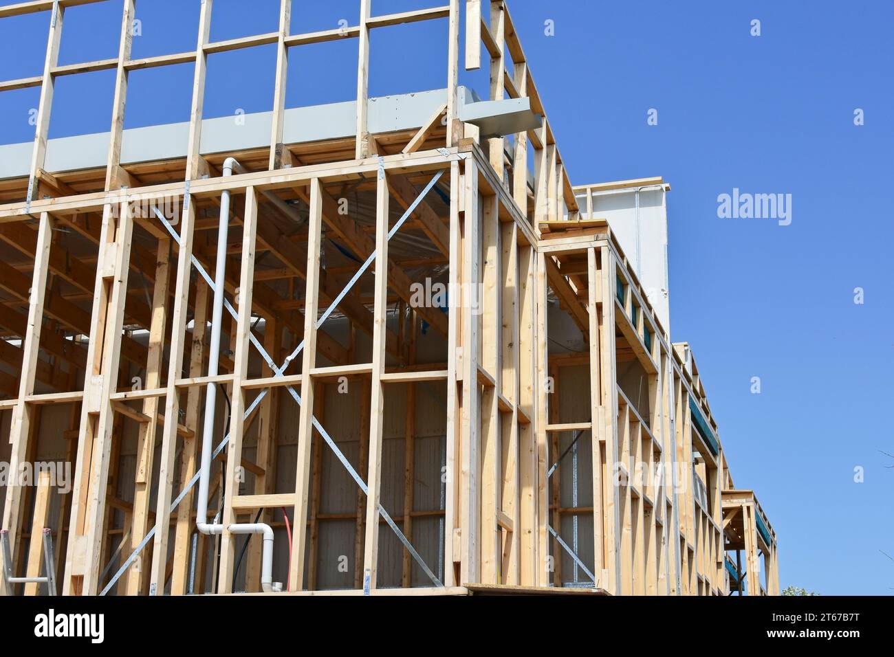 Ein neues Haus im Bau mit Holzrahmen und blauem Himmel. Stockfoto