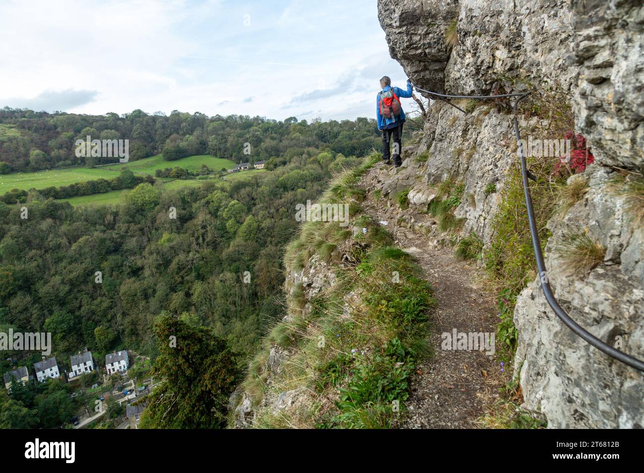 Ein Wanderer am Giddy Edge auf dem High Tor Hill ist ein schmaler, freiliegender Pfad entlang der Klippe mit Matlock Bath darunter Stockfoto