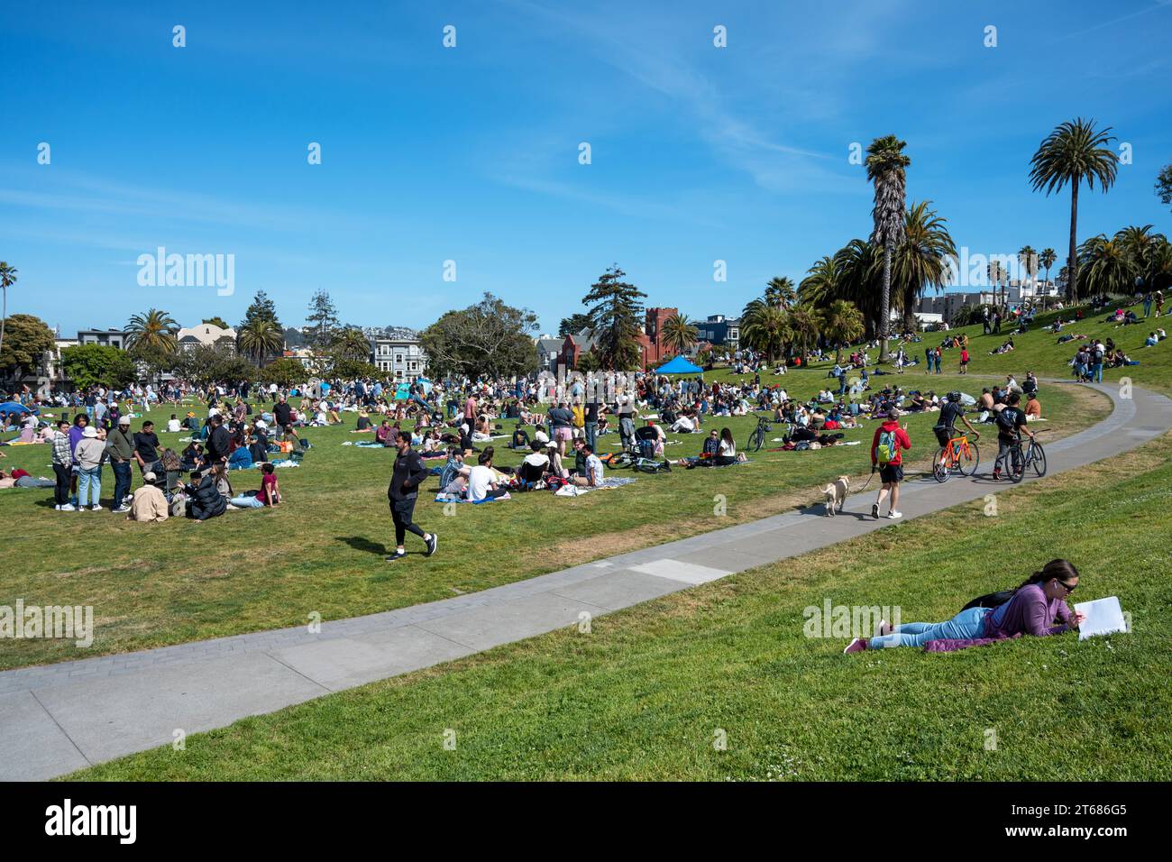 San Francisco, Kalifornien - 25. April 2023: Im Mission Dolores Park genießen die Menschen im Frühling ihre Freizeit vor blauem Himmel Stockfoto