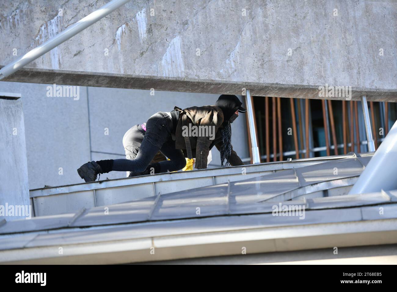 Edinburgh, Schottland, Großbritannien. November 2023. IM BILD: Demonstranten klettern auf die Fassade und das Dach des schottischen Parlaments und zeigen ein großes Stoffbanner mit der Aufschrift „STOP ARMIERUNG ISRAEL“ sowie zwei große palästinensische Nationalflaggen an der Fassade. Credit: Colin D Fisher Credit: Colin Fisher/Alamy Live News Stockfoto