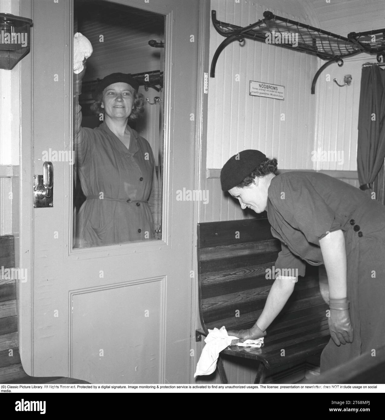 Arbeit in den 1940er Jahren Zwei Frauen werden beim Reinigen eines Zugwagens, des Glasfensters und der Holzsitze gesehen. Schweden September 1941. Kristoffersson 202-1 Stockfoto