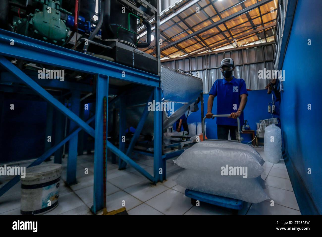 Arbeiter bereiten verpackte Kristalleiswürfel vor, die am 31. Oktober 2023 in Bogor, West Java, Indonesien, verkauft werden können Stockfoto