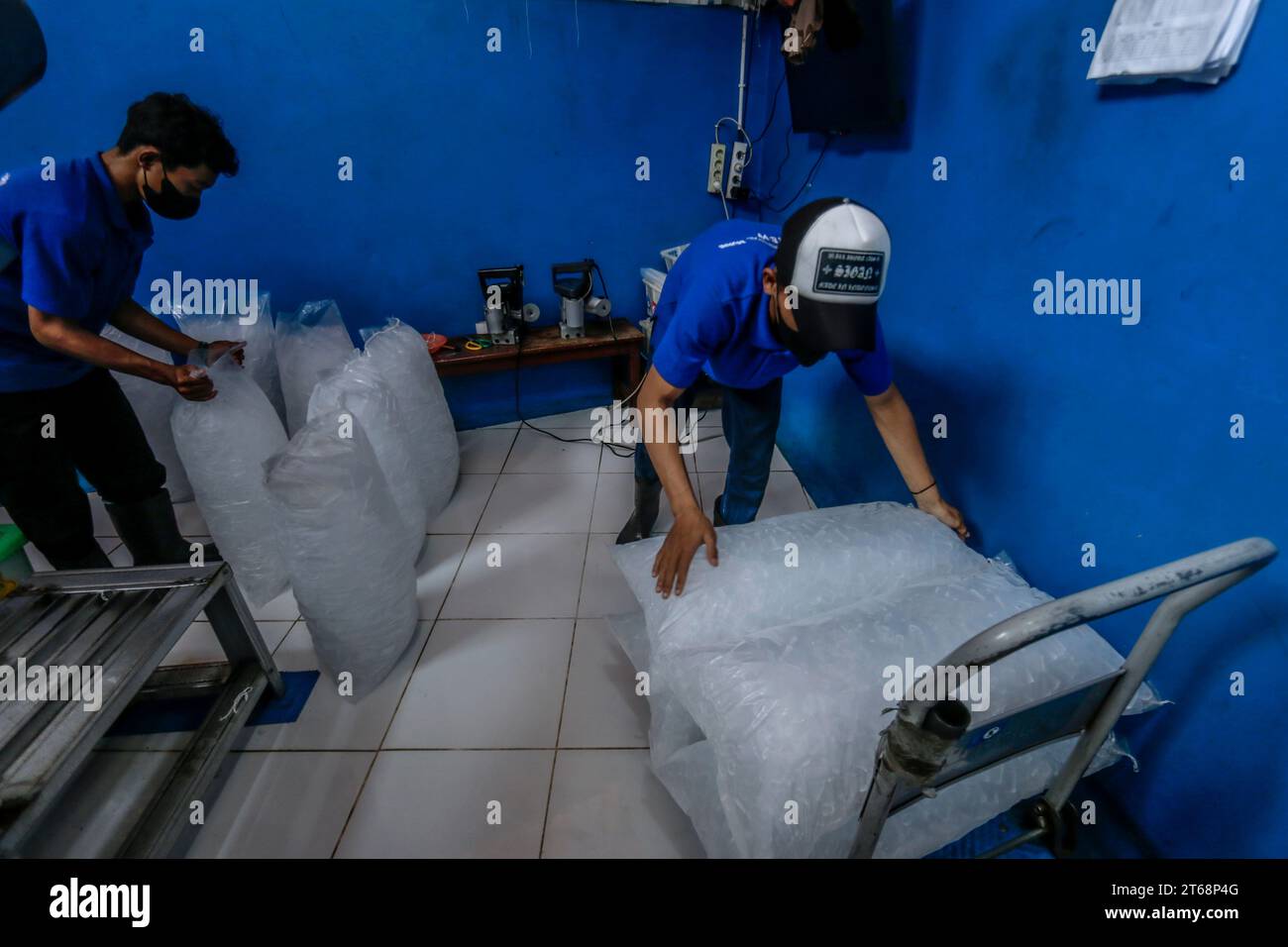 Arbeiter bereiten verpackte Kristalleiswürfel vor, die am 31. Oktober 2023 in Bogor, West Java, Indonesien, verkauft werden können Stockfoto