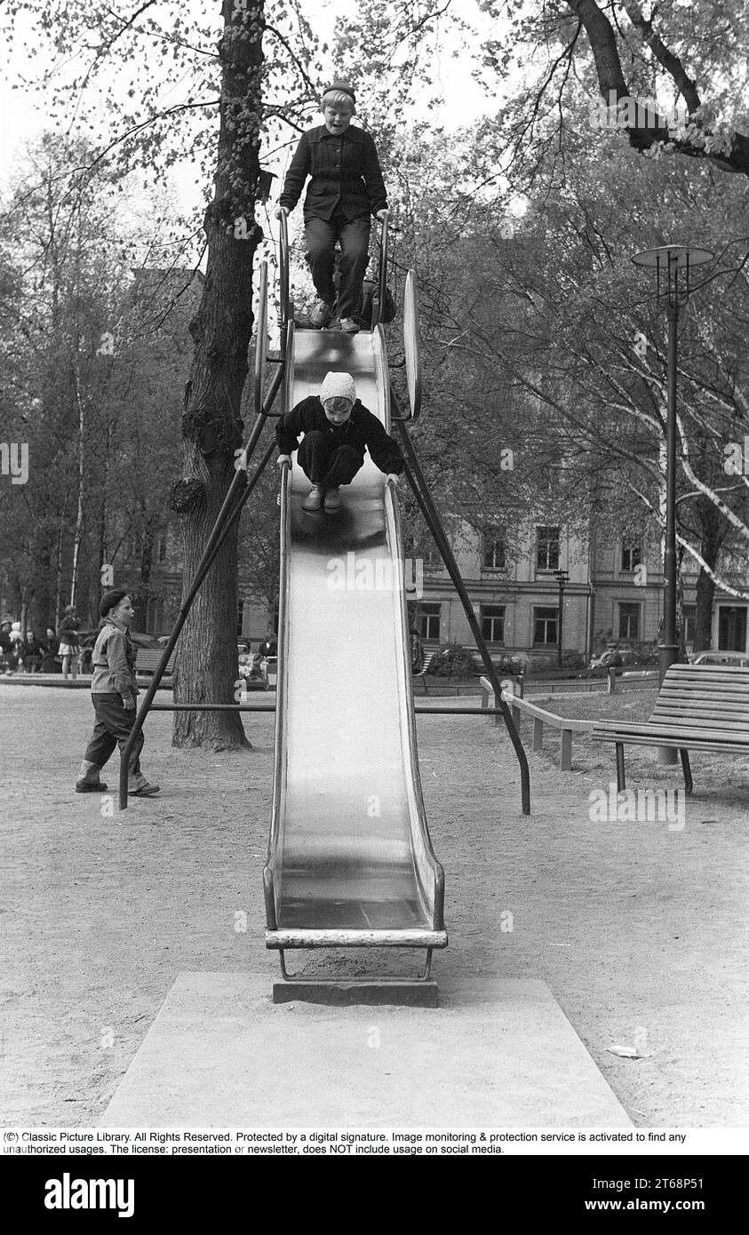 Spielplatz in den 1950er Jahren Kinder werden auf einer Rutsche in einem Park in Stockholm gesehen, Schweden 1954. Kristoffersson Ref. 1-38 Stockfoto