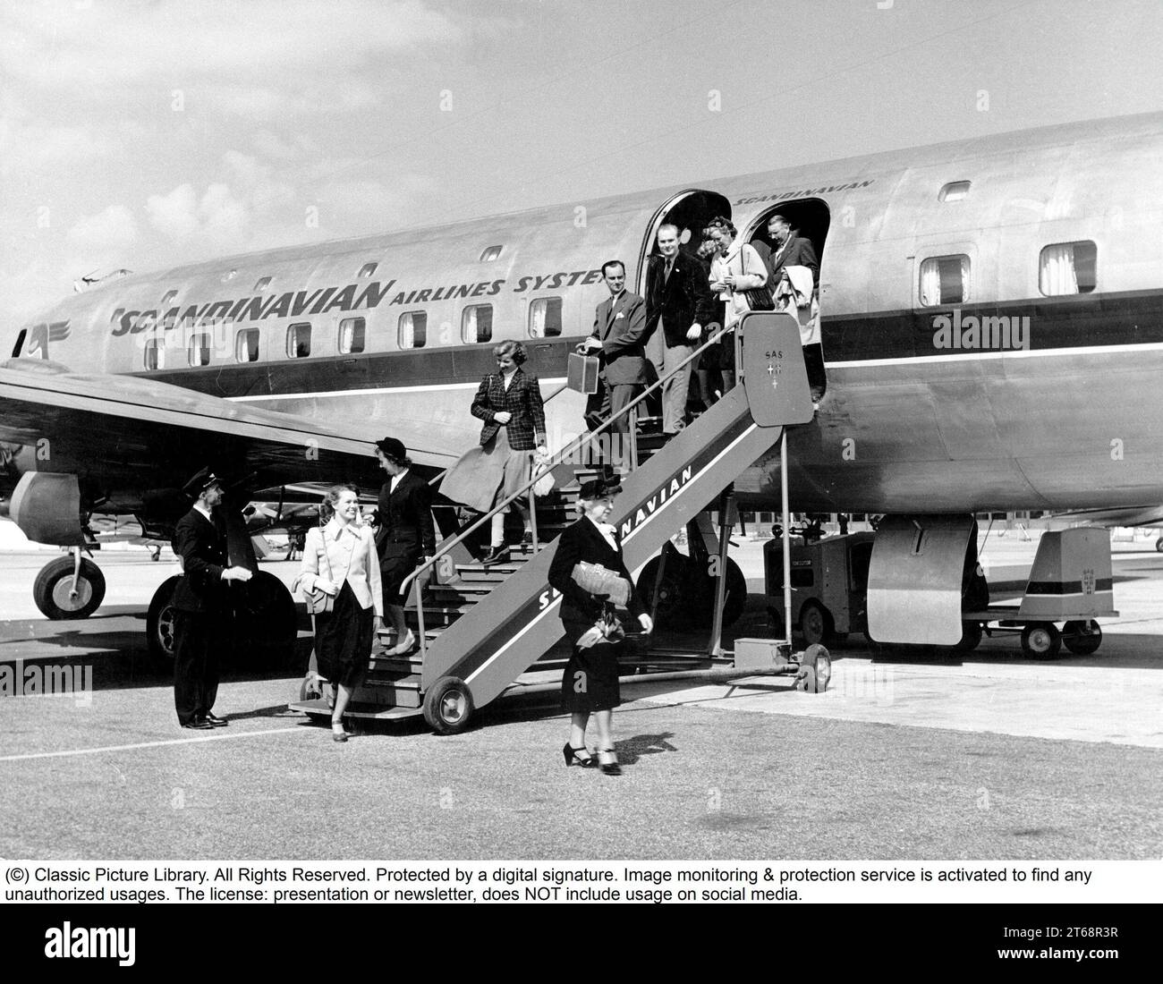 Flughafen der 1950er Jahre. Die Leute kommen mit einem Flug des skandinavischen Airline-Systems an und laufen die Treppe vom Flugzeug herunter. Schweden 1955 Stockfoto