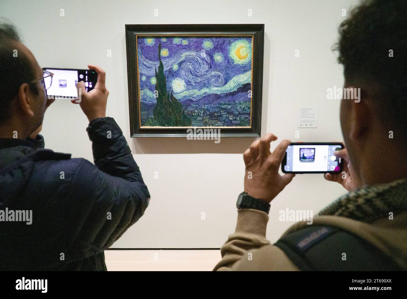 Manhattan, USA, 30. Oktober 2023: Besucher des MOMA in New York treffen sich um Vincent van Goghs „The Starry Night“ aus dem Jahr 1889. Das Gemälde, teilweise gemacht Stockfoto