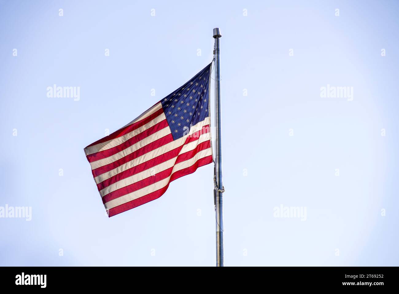 Die amerikanische Flagge winkt im Wind an der Fahnenstange. Der nationale rote, weiße und blaue Stern stiftete die US-Flagge. Die US-Flagge ist ein Symbol für Freiheit und Stolz Stockfoto