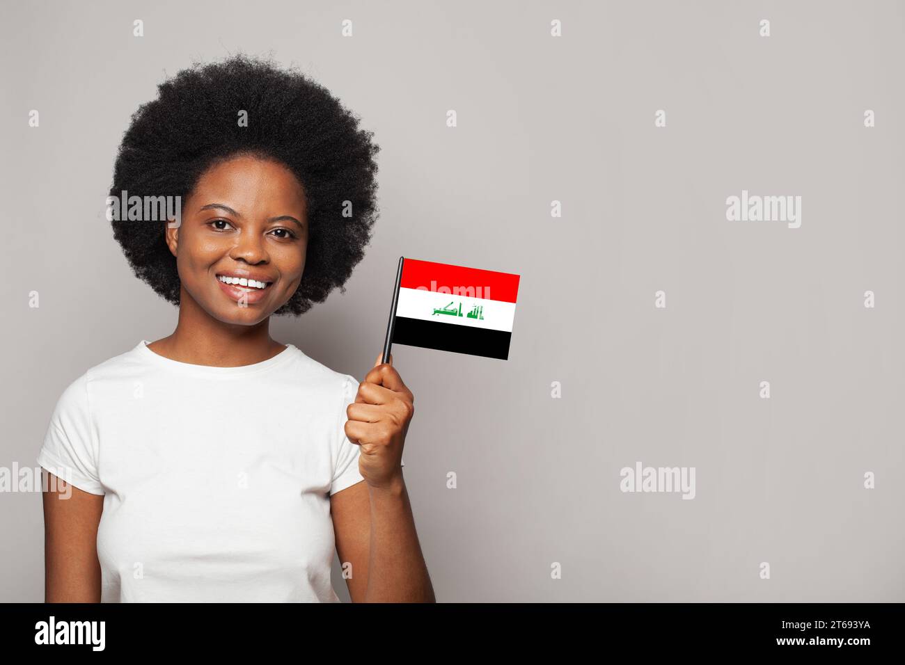 Irakische Frau, die Flagge des irakischen Konzepts für Bildung, Wirtschaft, Staatsbürgerschaft und Patriotismus hält Stockfoto