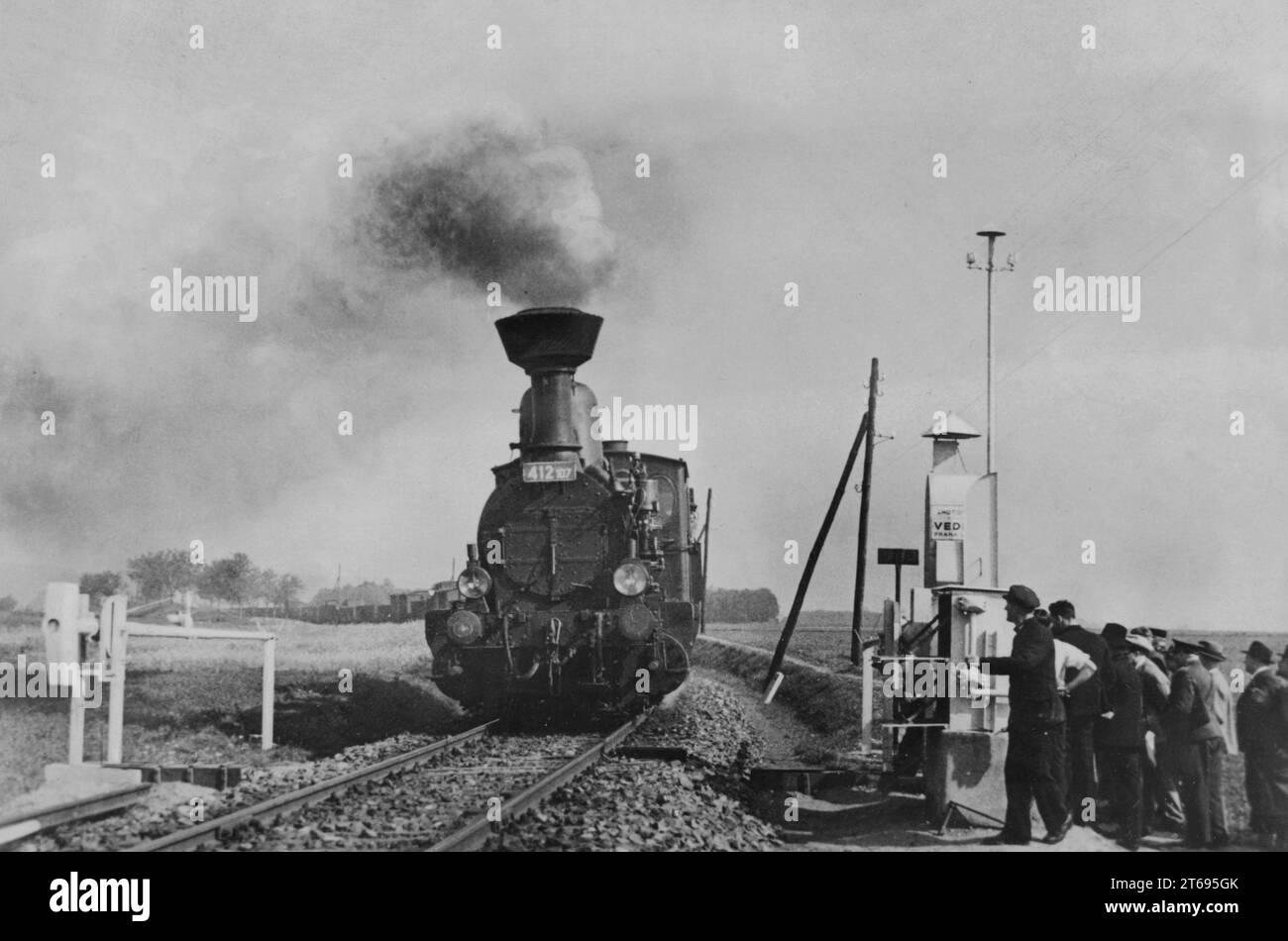 Ingenieur Fryba hat eine Vorrichtung erfunden, die automatisch die Barriere des Bahnübergangs schließt, wenn der sich nähernde Zug drückt, und so Unfälle verhindert. Hier die Demonstration einer Testinstallation. [Automatisierte Übersetzung] Stockfoto