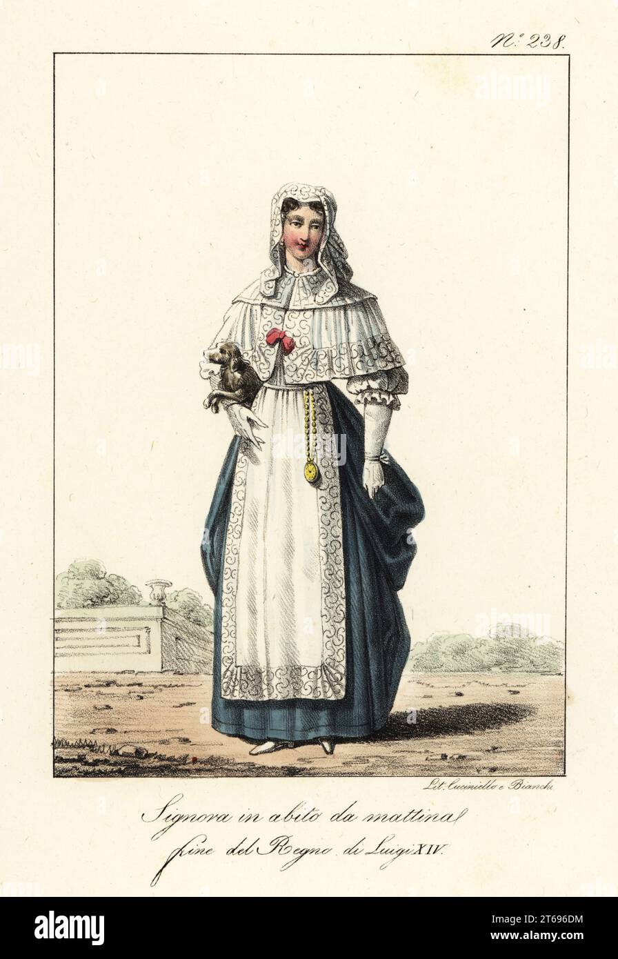 Frau im Morgenkleid, Ende der Herrschaft von König Ludwig XIV. Von Frankreich. Mit Spitzenschleier, spitzenumhang, blauem Kleid, Spitzenschürze, goldener Uhr an einer Kette, mit Spielzeughund unter dem Arm. Dame en Deshabille du matin, fin du Regne de Louis XIV Handkolorierte Lithographie von Lorenzo Bianchi und Domenico Cuciniello nach Hippolyte Lecomte aus Costumi civili e militari della monarchia francese dal 1200 al 1820, Neapel, 1825. Italienische Ausgabe der Lecomtes Zivil- und Militärkostüme der französischen Monarchie von 1200 bis 1820. Stockfoto