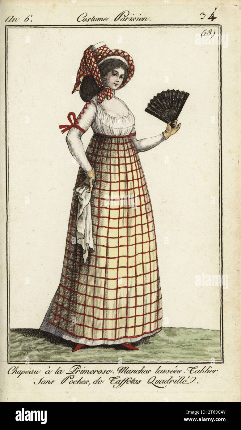 Frau in der Mode von 1798. Sie trägt einen Hut im Primerose-Stil, der mit einem karierten Fichu gebunden ist. Ihr Kleid hat geschnürte Ärmel und ihre Schürze ohne Tasche ist aus kariertem Taft. Sie hält einen Fächer und ein Taschentuch. Der Hut kann von dem Kostüm eines provenzalischen Bauern inspiriert sein, gespielt von Madame St. Aubin in Nicolas Dalayracs Oper Primerose, die 1798 debütierte. Chapeau a la primerose. Manches-Lasser. Tablier sans Poches de taffetas quadrille. Handkolorierter Kupferstich aus Pierre de la Mesangeres Journal des Modes et Dames, Paris, 1798. Die Illustrationen in Band 1 stammen von Carle Vernet, Claude Louis de Stockfoto