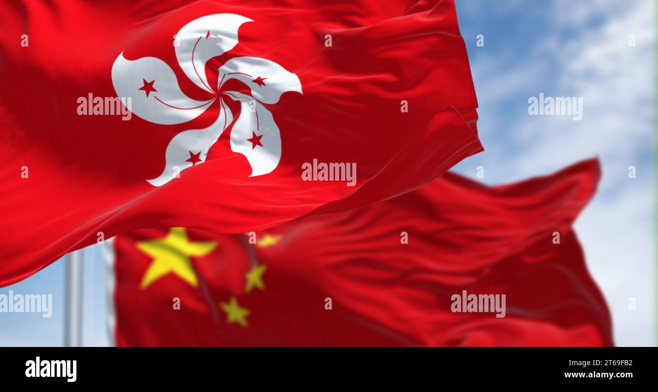 Flaggen von Hongkong und China winken an klaren Tagen im Wind. Hongkong ist eine Stadt und eine besondere Verwaltungsregion in China. Gewelltes Material. Sel Stockfoto