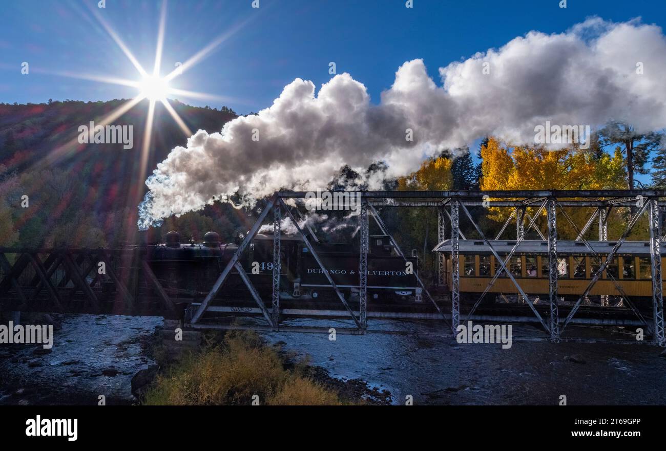 Der Durango & Silverton Zug überquert den Animas River und fährt in der Morgenröte in Richtung Silverton, Colorado Stockfoto