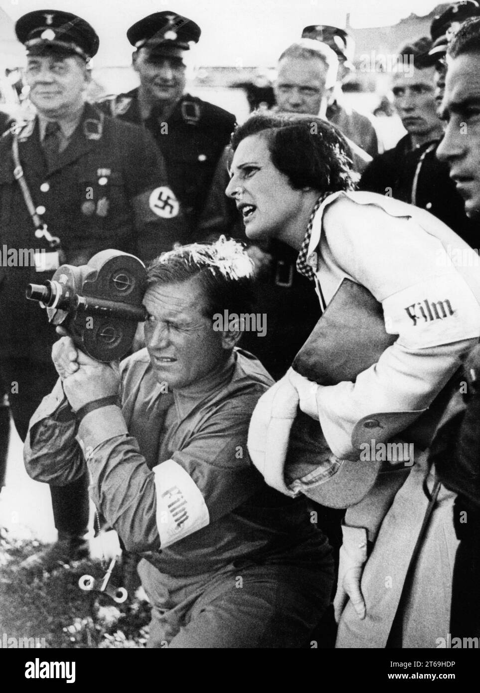 Kameramann Sepp Allgeier und Leni Riefenstahl bei der Dreharbeiten zum Film Triumph des Willens in Nürnberg. Hinter ihnen SS-Mitglieder. [Automatisierte Übersetzung] Stockfoto