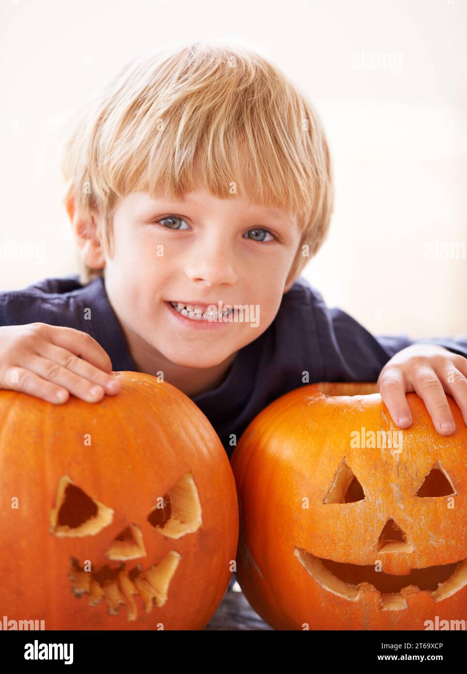 Seine eigenen Jack-o-Laternen. Porträt eines Jungen hinter zwei Windlichtern. Stockfoto