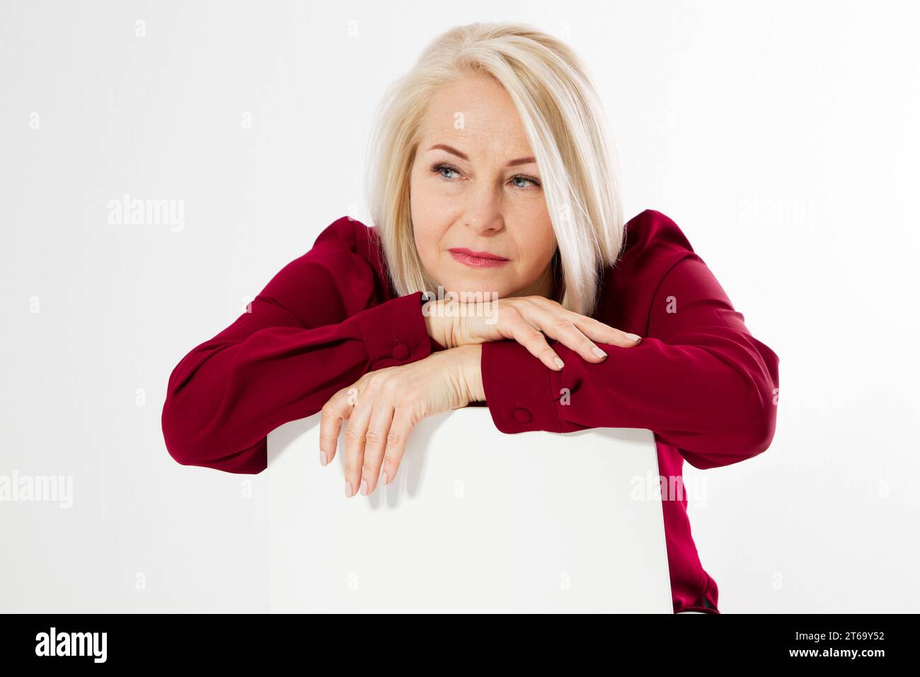 Traurige einsame Frau mittleren Alters. Weibliche Depression, Porträt einer Frau mittleren Alters, die auf einem Stuhl sitzt und traurig aussieht, Frau sieht traurig und niedergeschlagen aus, verärgert Stockfoto