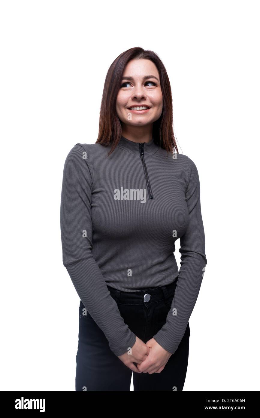 Kaukasische junge Frau in einer eng anliegenden Bluse auf weißem Hintergrund mit Kopierraum Stockfoto