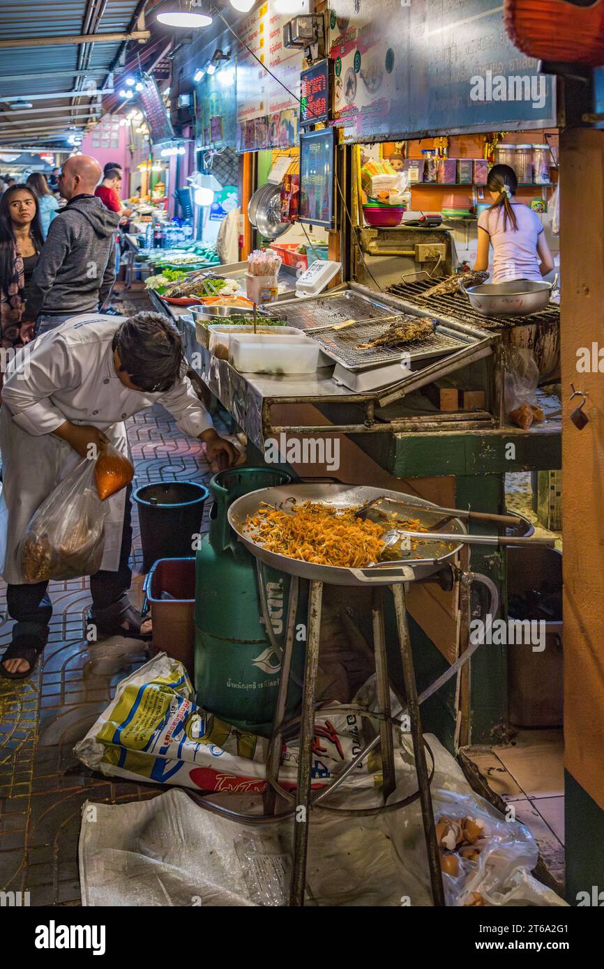 Thailändischer Straßenverkäufer, der auf dem Nachtmarkt in der Innenstadt von Chiang Rai, Thailand, Meeresfrüchte zubereitet Stockfoto