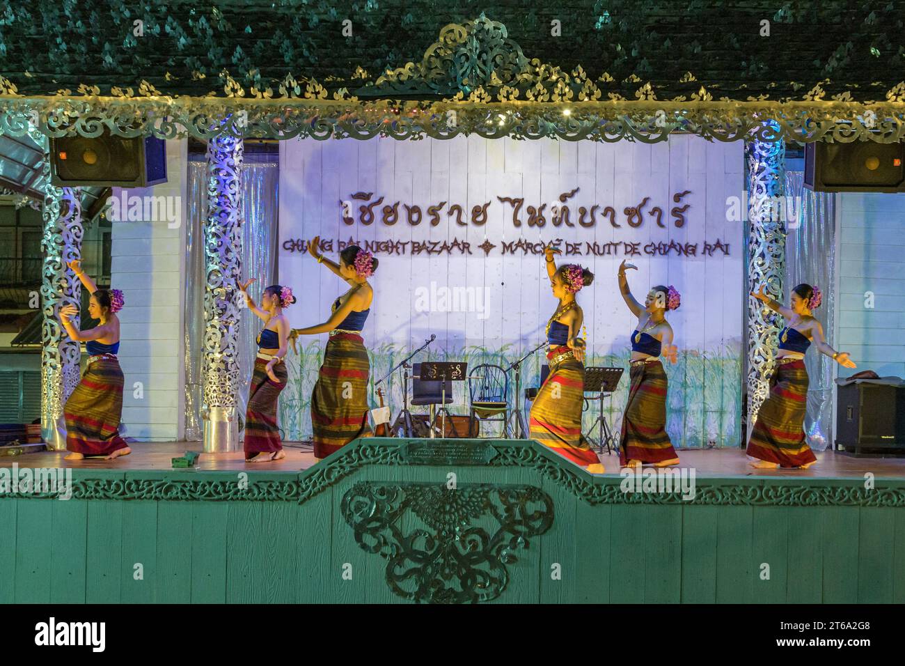 Traditionelle thailändische Tänzer treten auf einer beleuchteten Bühne auf dem Nachtmarkt in der Innenstadt von Chiang Rai, Thailand, auf Stockfoto