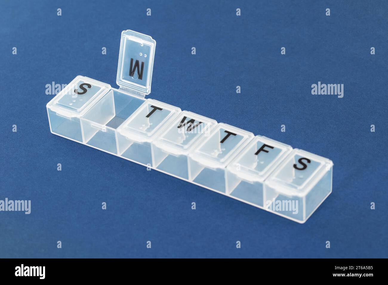 Pille Organizer, Pille Box auf blauem Hintergrund Nahaufnahme. Organisation der Einnahme von Tabletten des Tages. Stockfoto