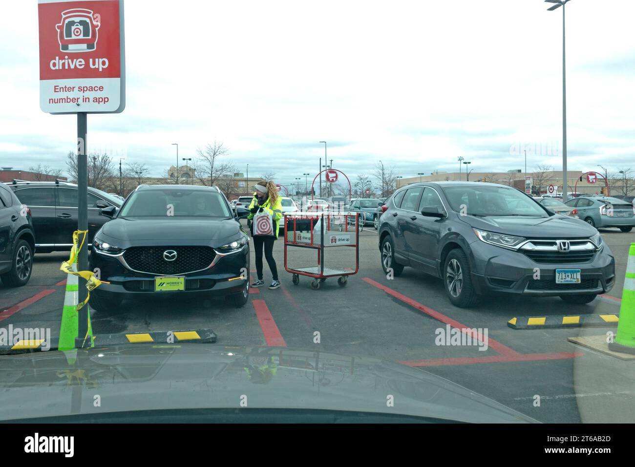 Das Ziel führt nach einem Anruf über die mobile App Target ein Mädchen aus, das Pakete an Autos in der angegebenen Auffahrzone zustellt. St. Paul Minnesota MN USA Stockfoto