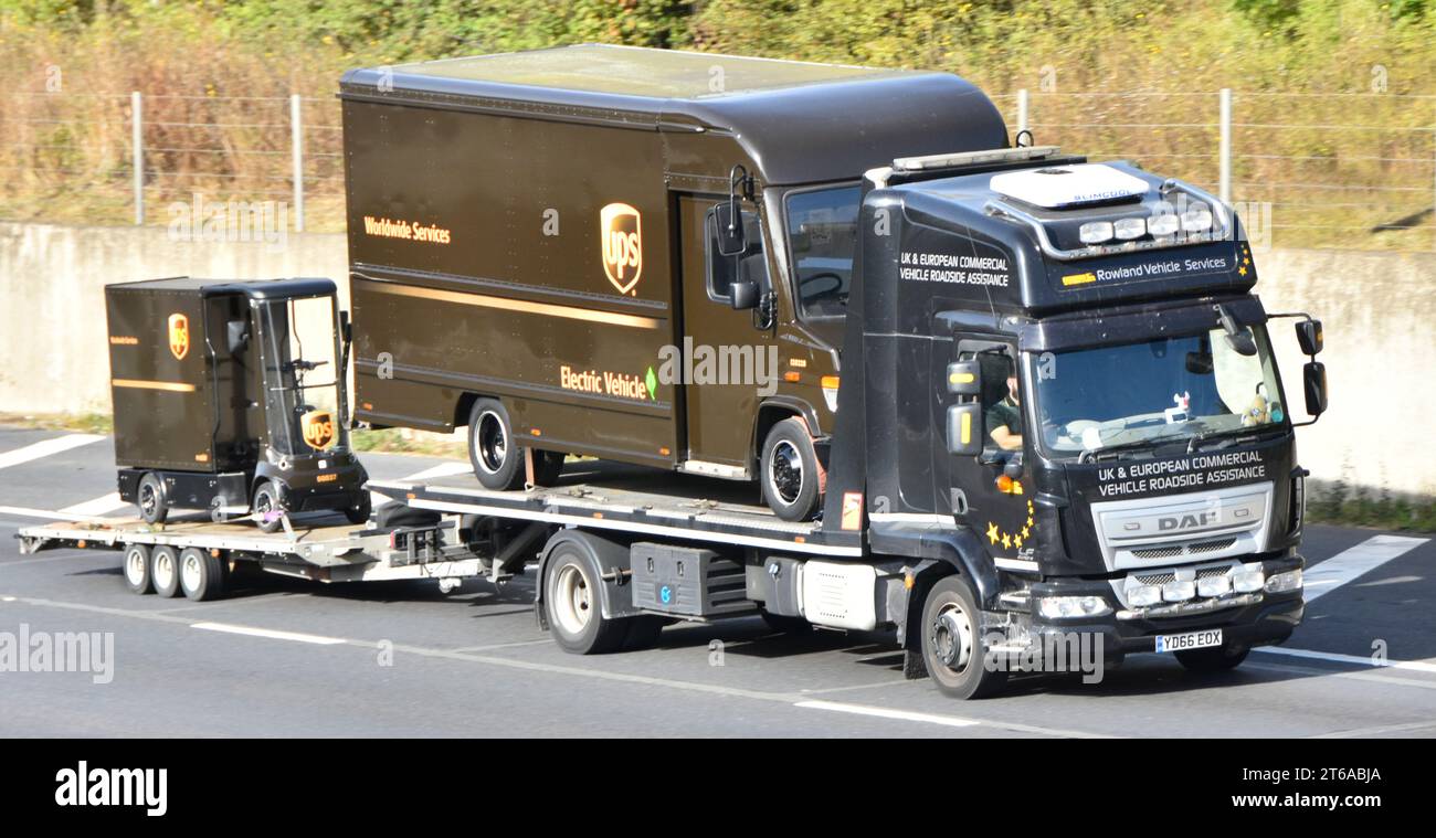 UPS elektrischer Paketwagen mit Miniatur-USV-Frachtwagen, geladen auf DAF-Flachplattform, Lastkraftwagen M25 Road England Großbritannien Stockfoto