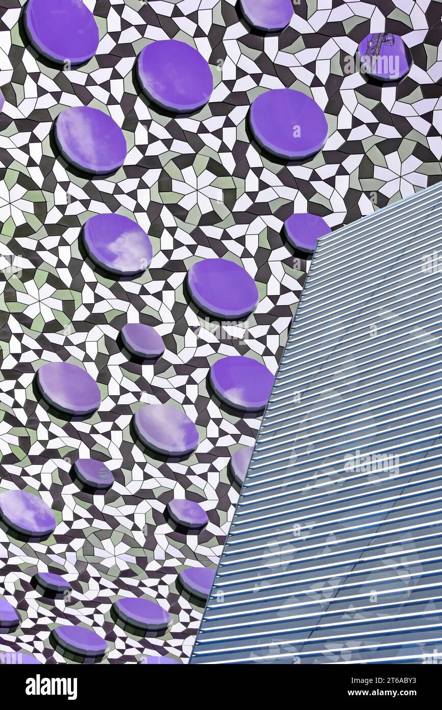 Abstrakte Nahaufnahme der architektonischen Gebäudeverkleidung, die Farbe auf kreisförmigen erhöhten Paneelen mit kariertem Hintergrund mit Grilllinien verändert wurde England UK Stockfoto