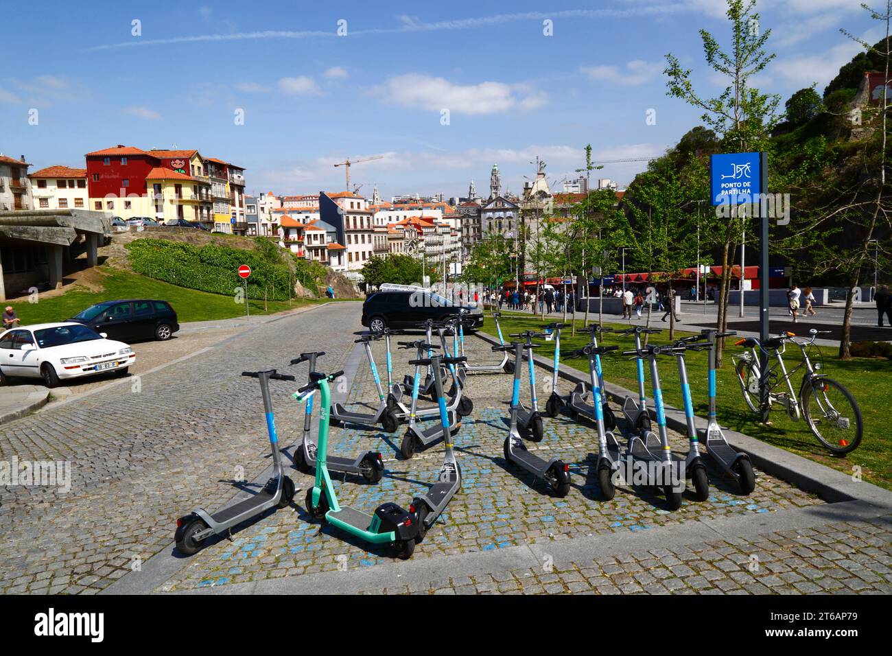 Elektroroller parken am Sharing Point, Igreja dos Congregados Kirche und Rathausturm in der Ferne, Ribeira, Porto / Porto, Portugal Stockfoto