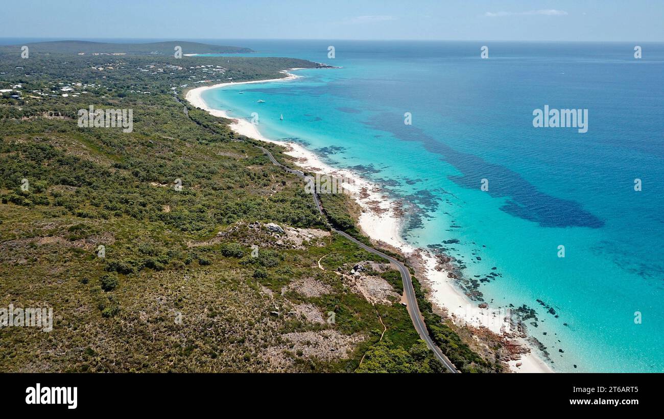 Ein ruhiger Strand mit unberührtem Sand und einem ruhigen türkisfarbenen Meer im Hintergrund Stockfoto