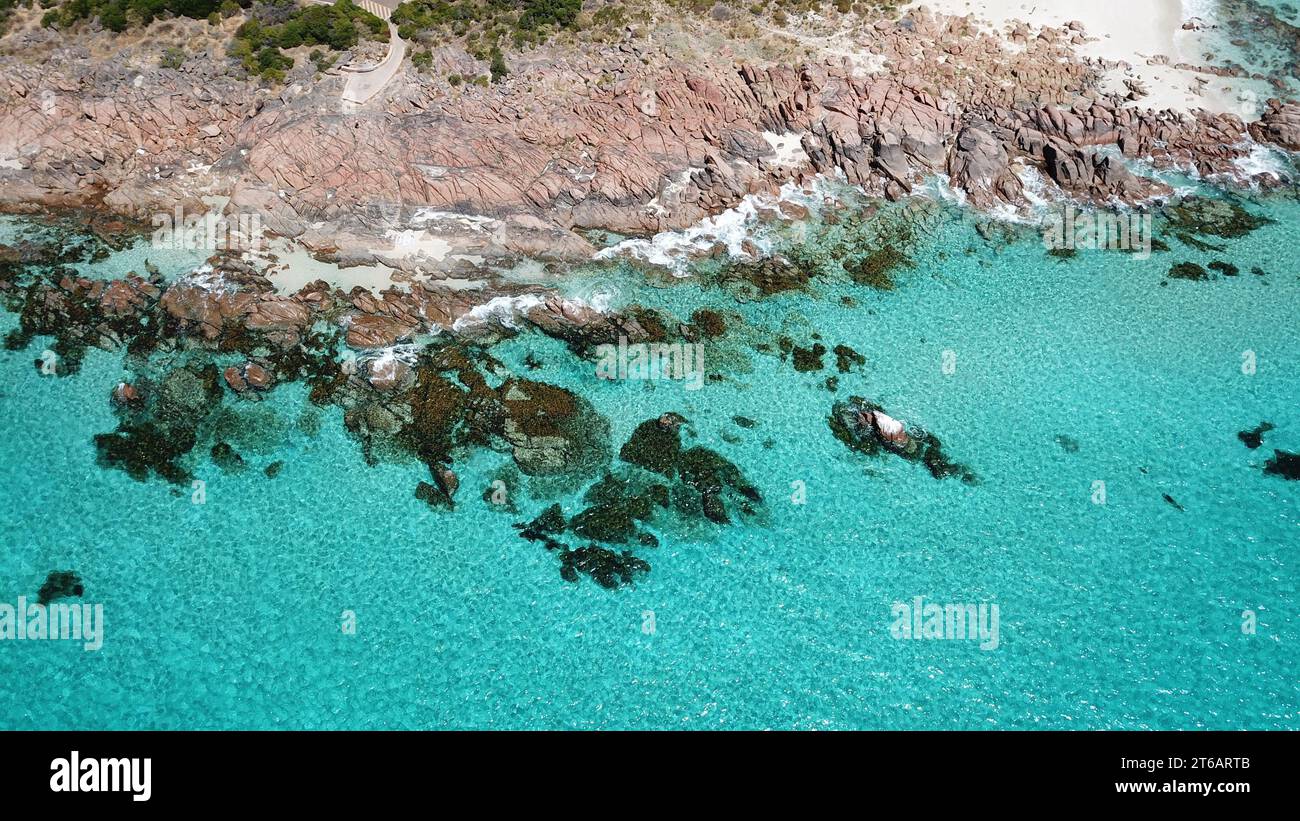 Ein ruhiger Strand mit unberührtem Sand und einem ruhigen türkisfarbenen Meer im Hintergrund Stockfoto