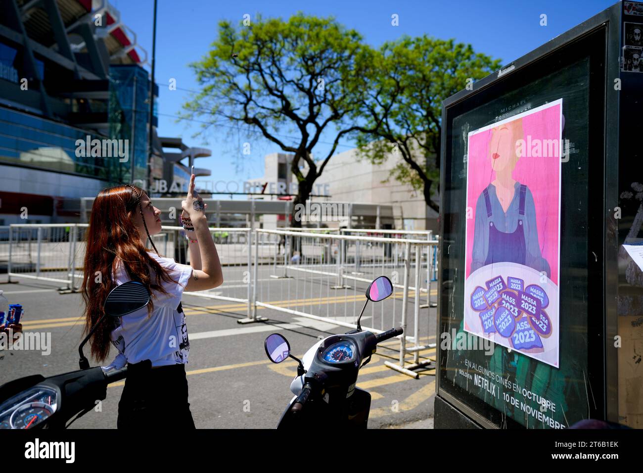 A fan of Taylor Swift takes a picture of a presidential election campaign sign that reads "Massa 2023" at the Monumental stadium before its doors open for the Eras Tour concert in Buenos Aires, Argentina, Thursday, Nov. 9, 2023. Argentine Economy Minister Massa will face Javier Milei in a presidential run-off election on Nov. 19. (AP Photo/Natacha Pisarenko) Stockfoto