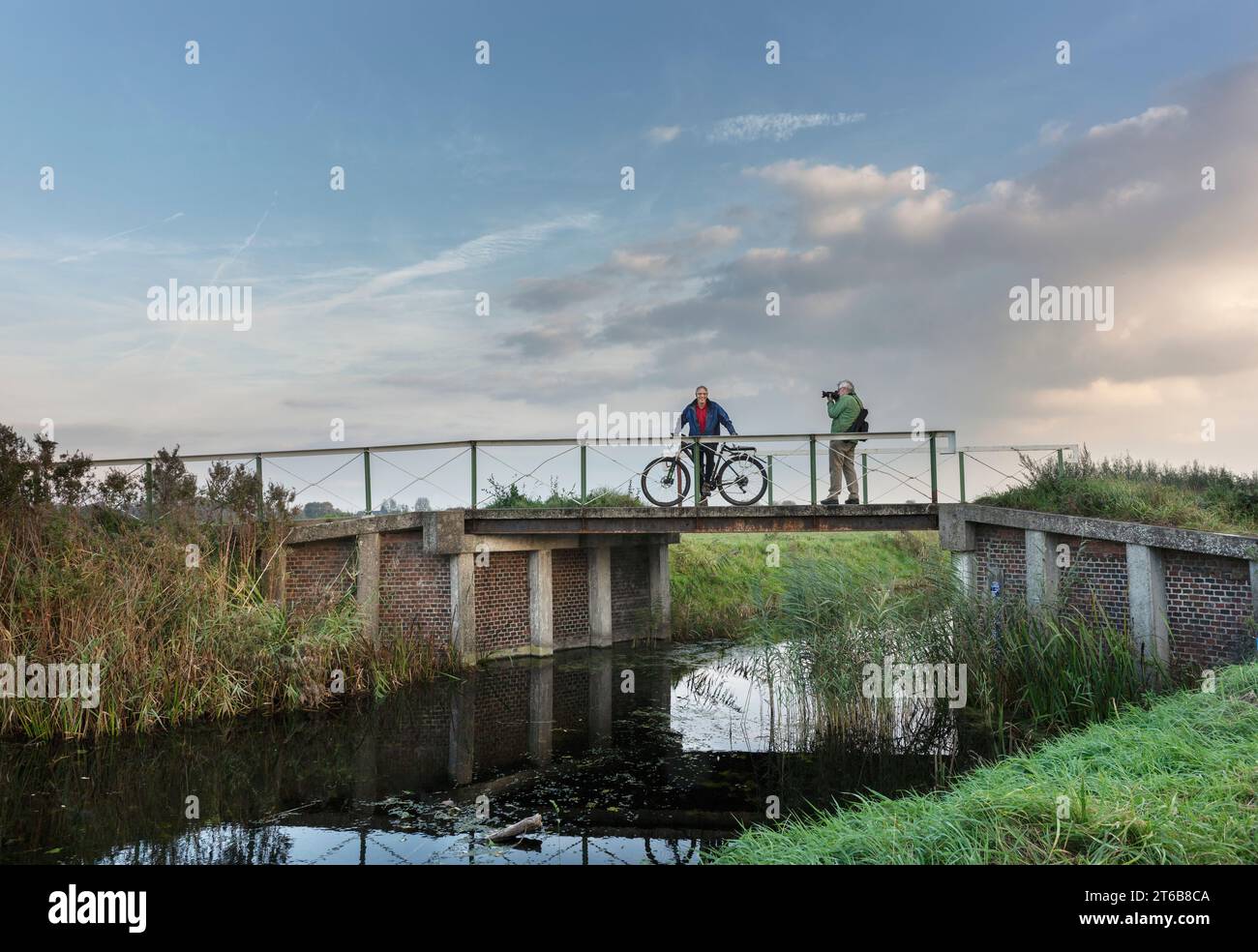 Noorddijk, Groningen, 10-20-2018. Ein Radfahrer wird auf der Brücke über den Zuidwending Kanal in Noorddijk am Stadtrand von Gro fotografiert Stockfoto